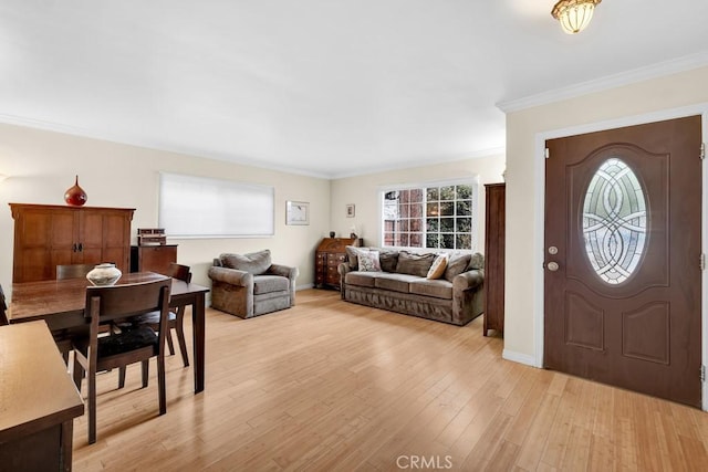 foyer entrance featuring crown molding, light wood-style flooring, and baseboards