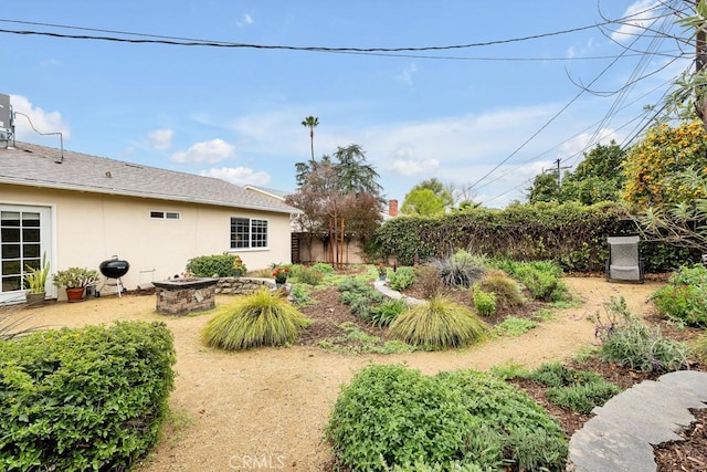 view of yard with a fire pit and fence