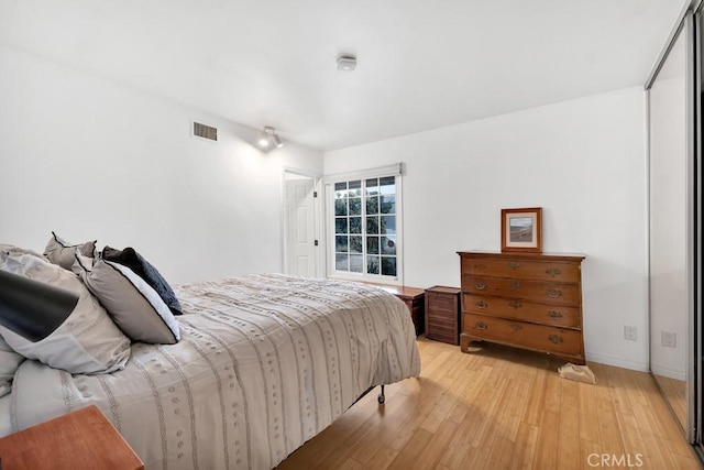 bedroom with light wood finished floors and visible vents