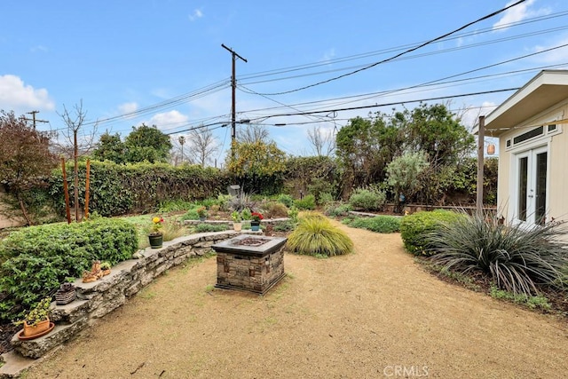 view of yard with french doors and an outdoor fire pit