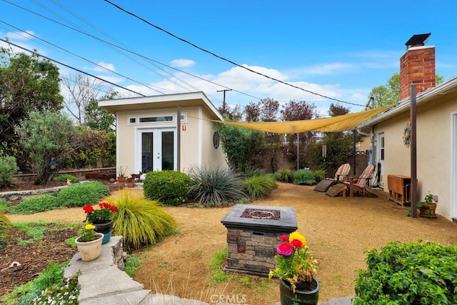 view of yard featuring an outbuilding, french doors, and a fire pit