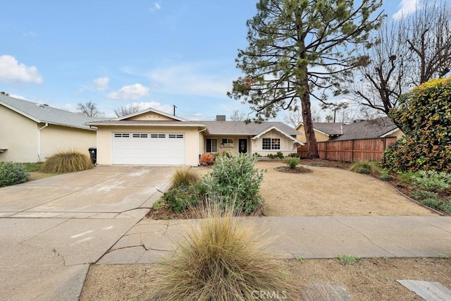 ranch-style house featuring stucco siding, driveway, an attached garage, and fence