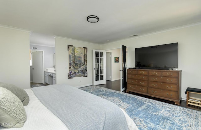 bedroom with visible vents, crown molding, and wood finished floors