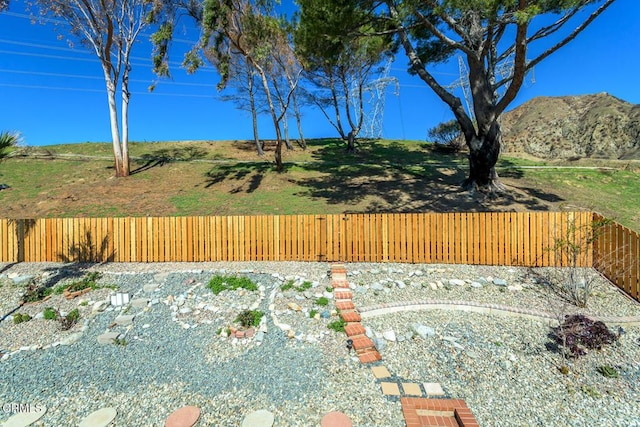 view of yard featuring fence and a mountain view