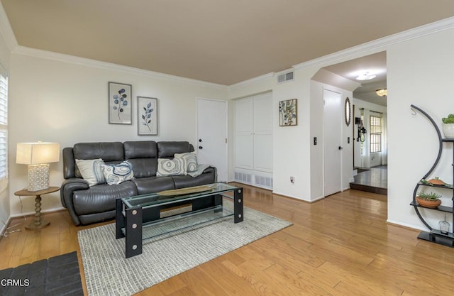 living area with visible vents, ornamental molding, baseboards, and hardwood / wood-style floors