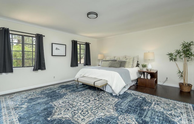 bedroom featuring baseboards, multiple windows, wood finished floors, and crown molding