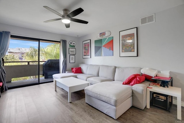 living area featuring visible vents, wood finished floors, and a ceiling fan