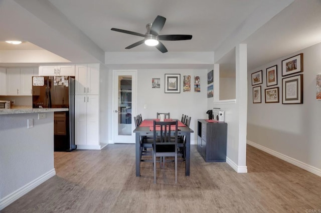 dining area with a ceiling fan, baseboards, and light wood finished floors