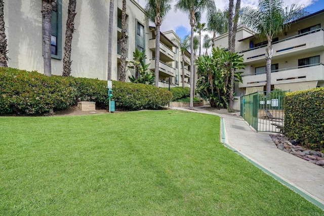 view of community featuring a yard and fence