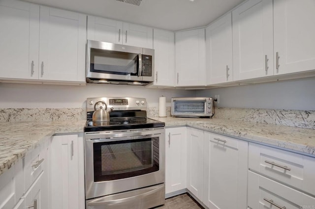 kitchen with stainless steel appliances, white cabinets, and a toaster