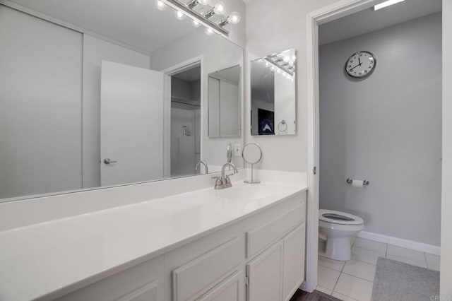 bathroom with tile patterned floors, baseboards, toilet, and vanity