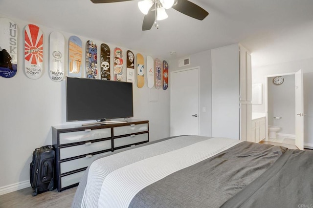 bedroom featuring baseboards, visible vents, ensuite bath, light wood-style flooring, and ceiling fan