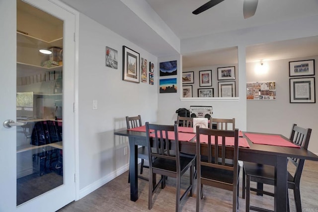 dining space with baseboards, ceiling fan, and wood finished floors