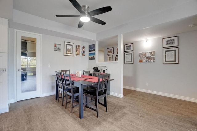 dining room with ceiling fan, baseboards, and wood finished floors