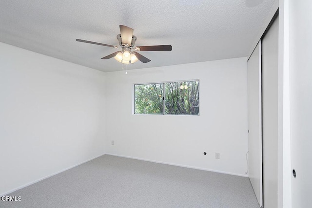 unfurnished bedroom with ceiling fan, carpet flooring, and a textured ceiling