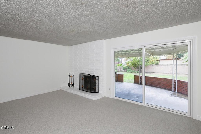 unfurnished living room featuring baseboards, carpet floors, a textured ceiling, and a fireplace