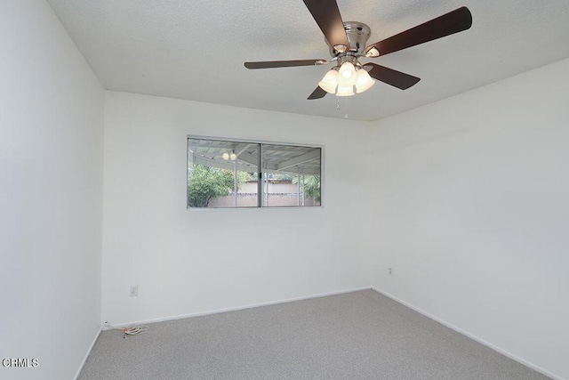 carpeted empty room with a ceiling fan, baseboards, and a textured ceiling