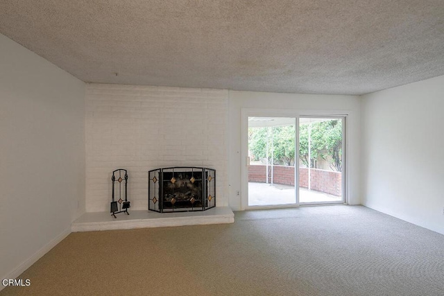unfurnished living room featuring a fireplace, carpet floors, and a textured ceiling