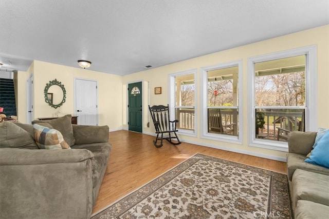 living room with visible vents, plenty of natural light, and wood finished floors