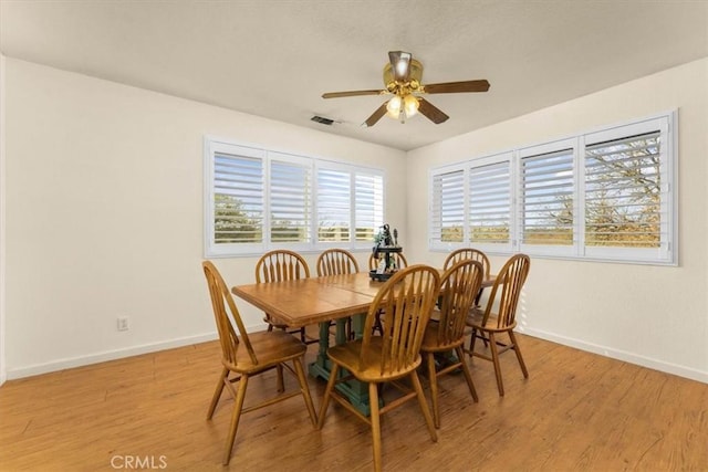 dining area with visible vents, baseboards, light wood-type flooring, and ceiling fan