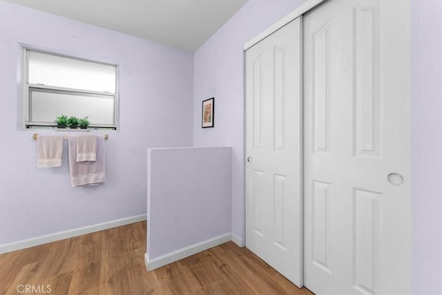 unfurnished bedroom with a closet, baseboards, and wood finished floors