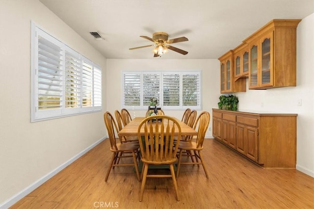 dining area with baseboards, visible vents, light wood finished floors, and ceiling fan