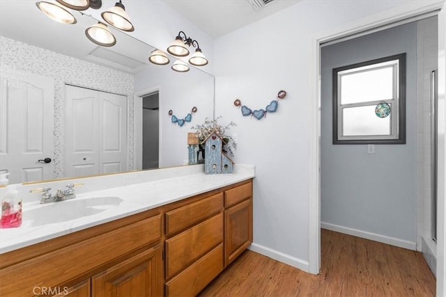 bathroom featuring baseboards, wood finished floors, and vanity