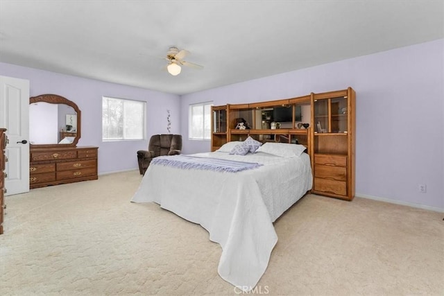 carpeted bedroom featuring baseboards and a ceiling fan