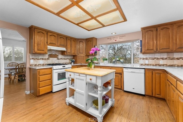 kitchen featuring open shelves, light wood-type flooring, white appliances, and under cabinet range hood