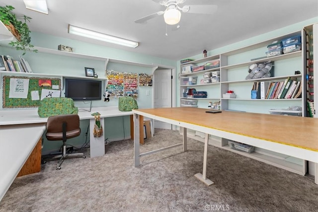 carpeted office with built in desk and ceiling fan