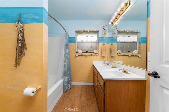 full bathroom featuring vanity, shower / bath combo with shower curtain, baseboards, and wood finished floors