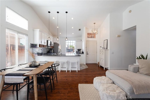 dining area with visible vents, high vaulted ceiling, dark wood finished floors, an inviting chandelier, and recessed lighting