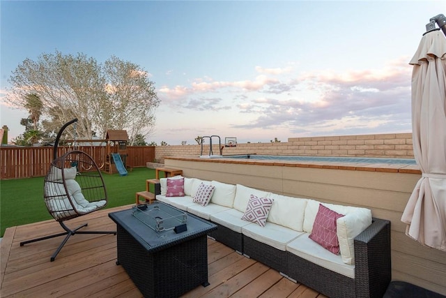 wooden terrace with outdoor lounge area, a playground, a yard, and a fenced backyard