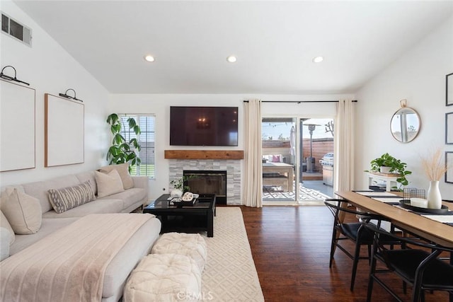 living room featuring visible vents, lofted ceiling, a healthy amount of sunlight, and dark wood finished floors