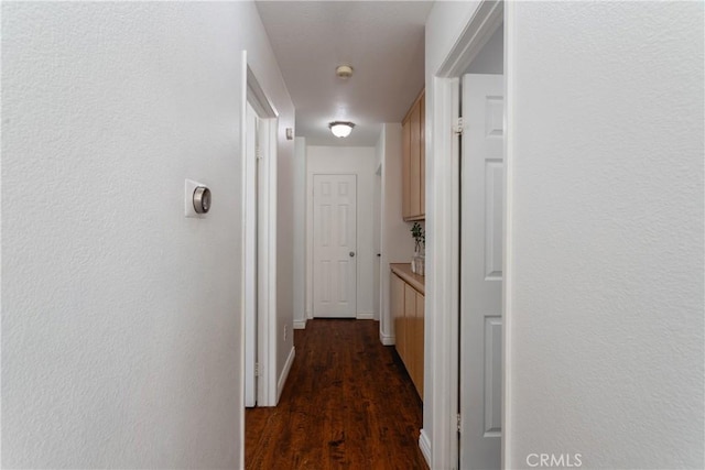 hall featuring baseboards and wood finished floors