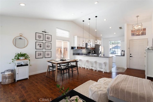 dining room with visible vents, dark wood-type flooring, high vaulted ceiling, recessed lighting, and baseboards