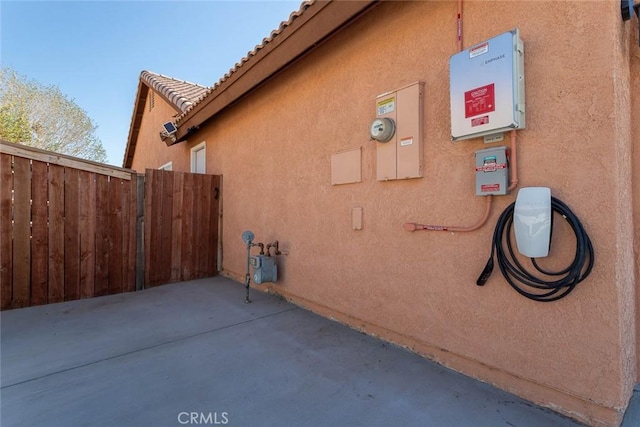 view of property exterior featuring stucco siding, a patio area, and fence