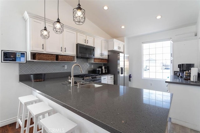 kitchen featuring white cabinets, backsplash, appliances with stainless steel finishes, and a sink