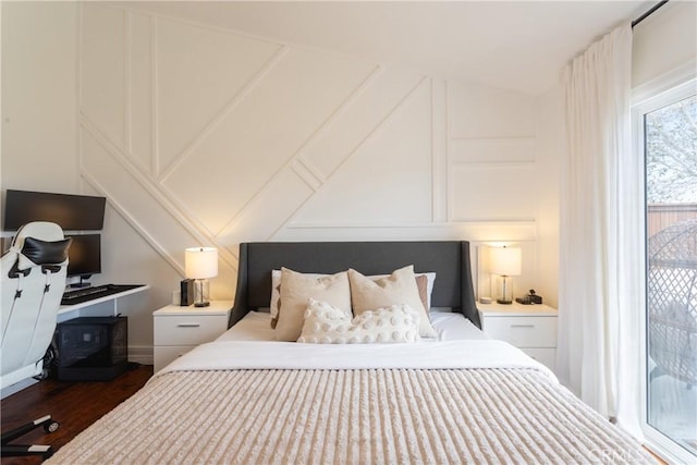 bedroom with dark wood-type flooring and a decorative wall