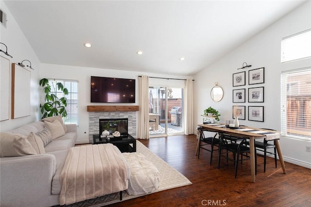 living room with a fireplace, lofted ceiling, and dark wood-style flooring