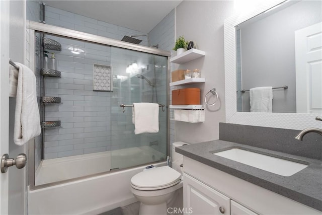 bathroom with toilet, vanity, and shower / bath combination with glass door