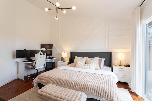 bedroom featuring vaulted ceiling, a decorative wall, and wood finished floors