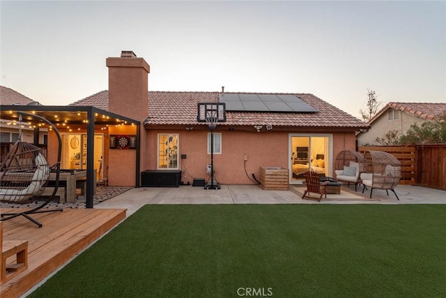 rear view of property with a tiled roof, a yard, a fire pit, and a chimney