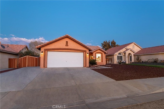 mediterranean / spanish-style home featuring fence, driveway, an attached garage, stucco siding, and a tile roof