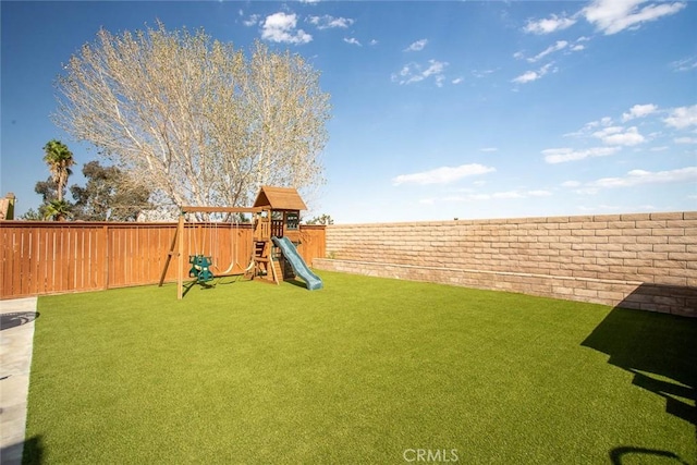 view of yard featuring a playground and a fenced backyard