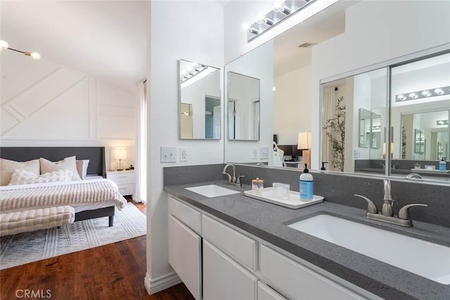 full bath featuring double vanity, wood finished floors, visible vents, and a sink