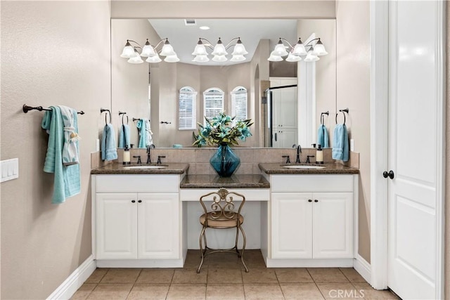 bathroom with a sink, double vanity, a shower stall, and tile patterned flooring