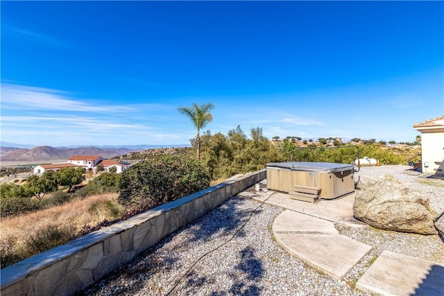 view of yard with a mountain view and a hot tub