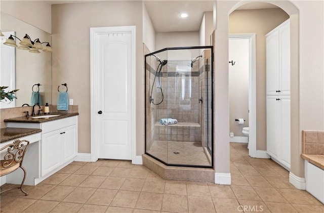 bathroom with vanity, a shower stall, toilet, and tile patterned floors