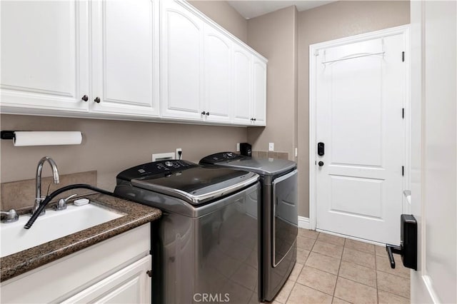 clothes washing area with a sink, cabinet space, separate washer and dryer, and light tile patterned floors